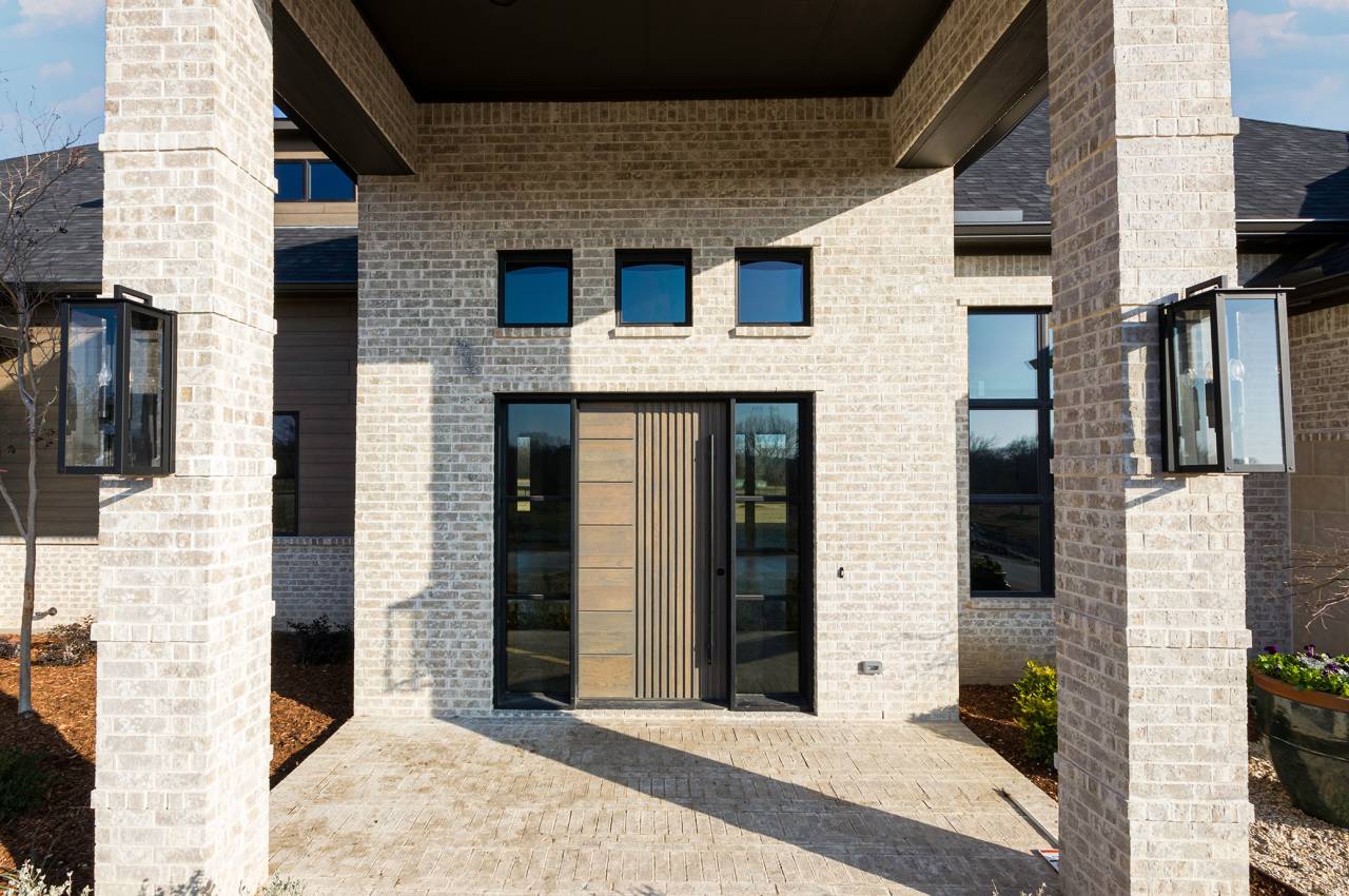 Beautiful covered exterior entry featuring wood door and decorative lighting.