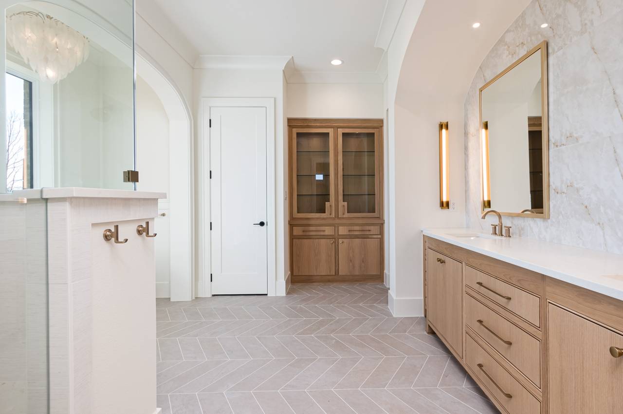 Look at the details in this primary bathroom - hooks for your towels and a gorgeous linen cabinet.