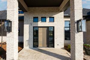 Beautiful covered exterior entry featuring wood door and decorative lighting.