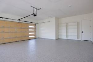 4-car garage with a epoxied floor and shelving.